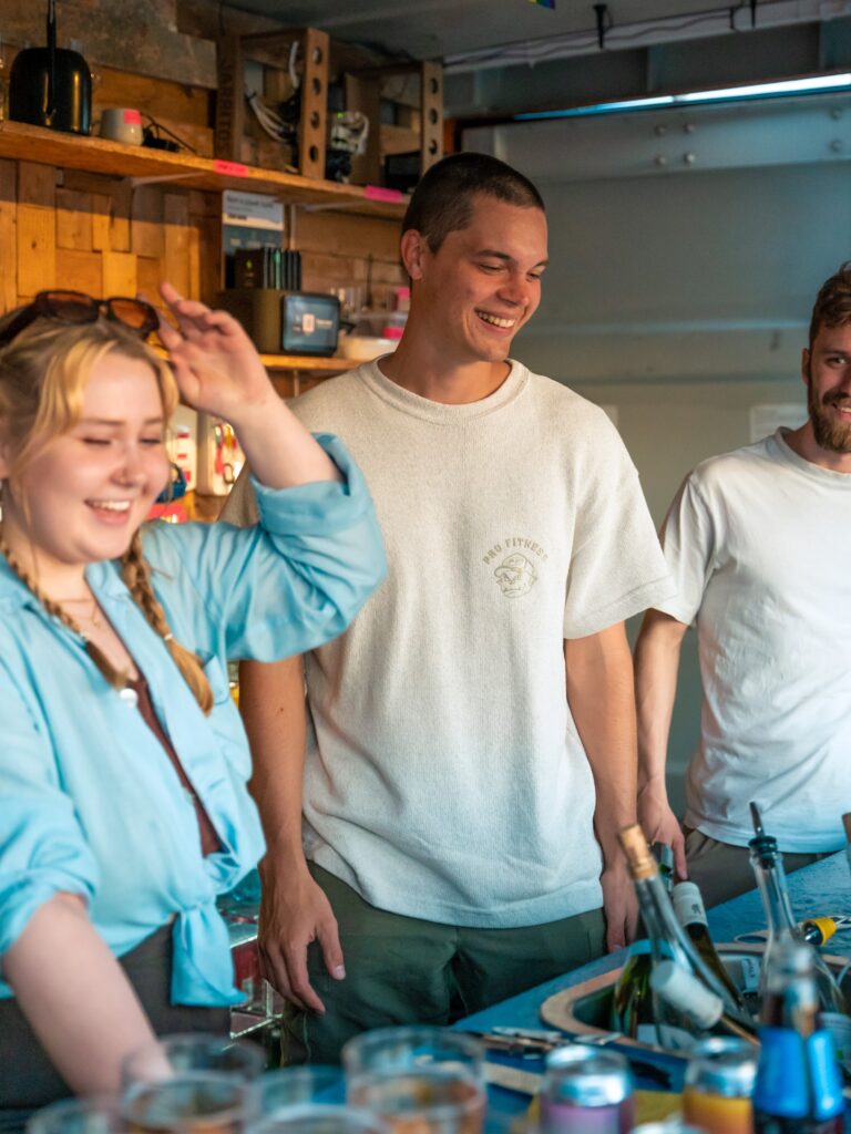 Smilende bartendere bak bardisk